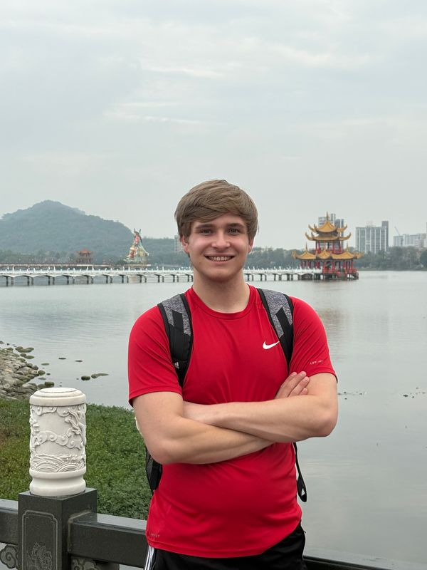 Blake smiling by Lotus Pond in Kaohsiung, with pagodas behind him