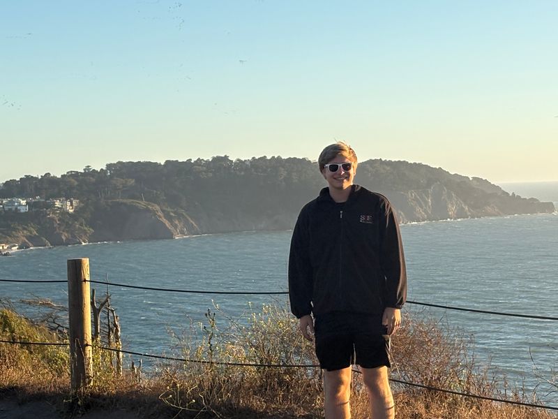 Blake standing above the Pacific near the Golden Gate at sunset
